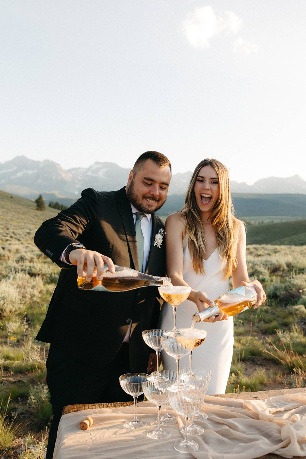 Bride and groom pouring champagne into glasses