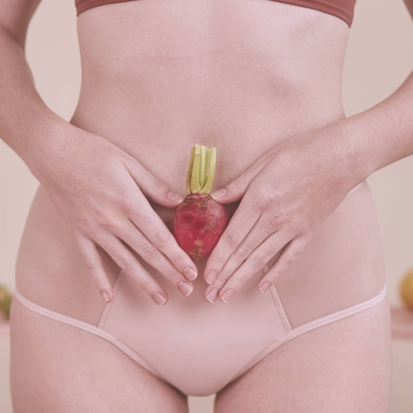 Mulher segurando um vegetal em sua barriga