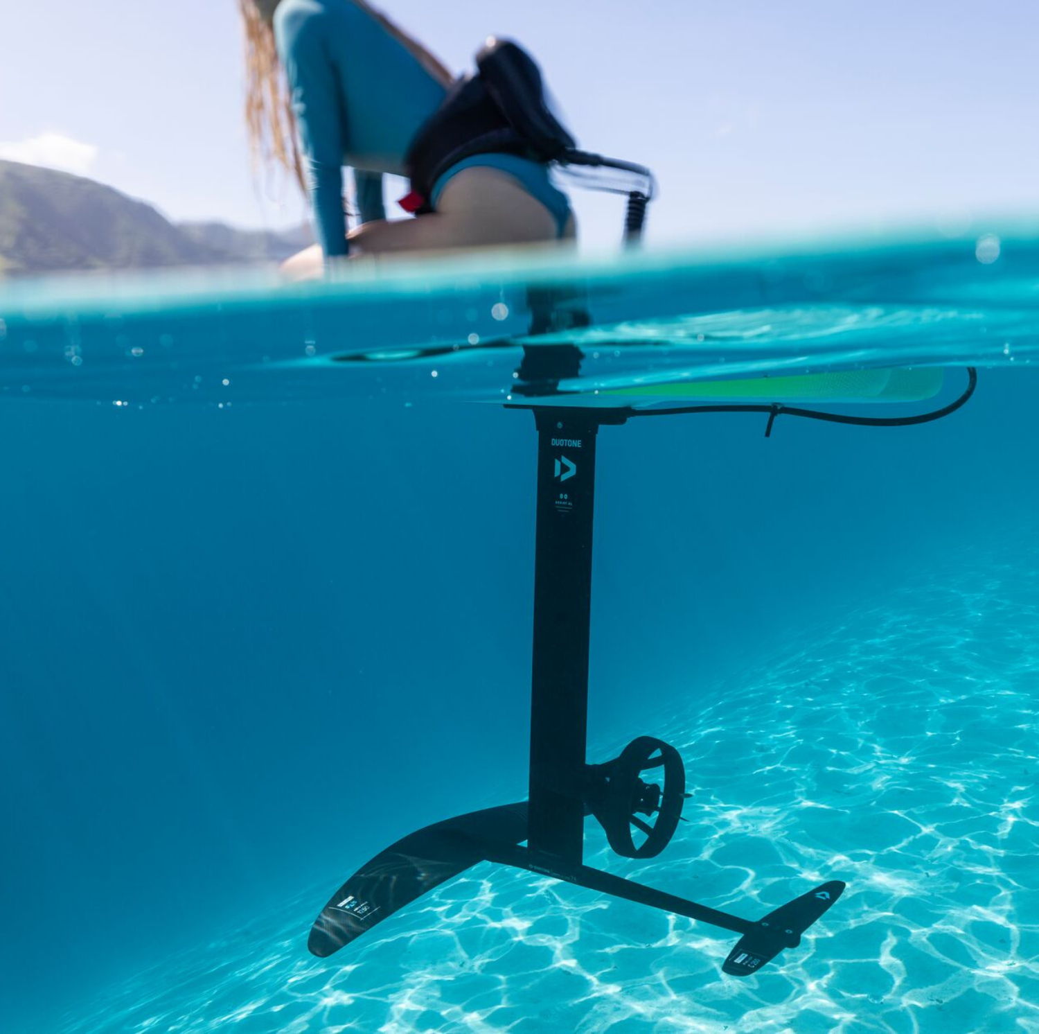 A person riding a e-foil board above water.