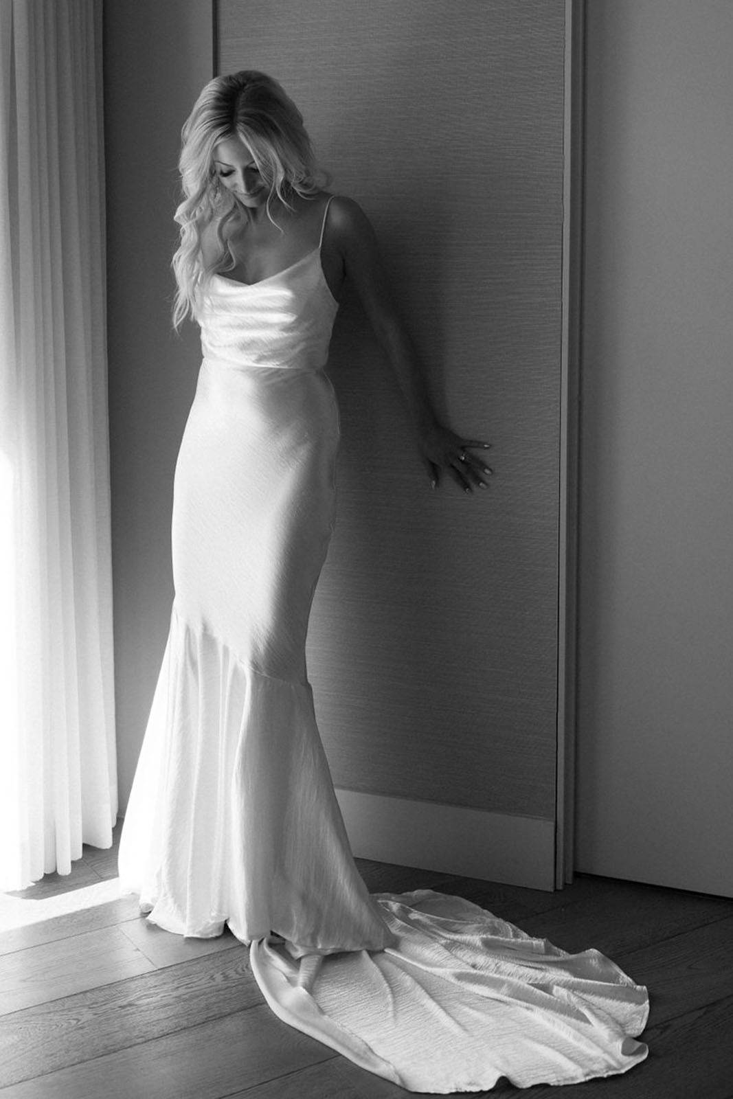 Bride poses with her dress, looking down