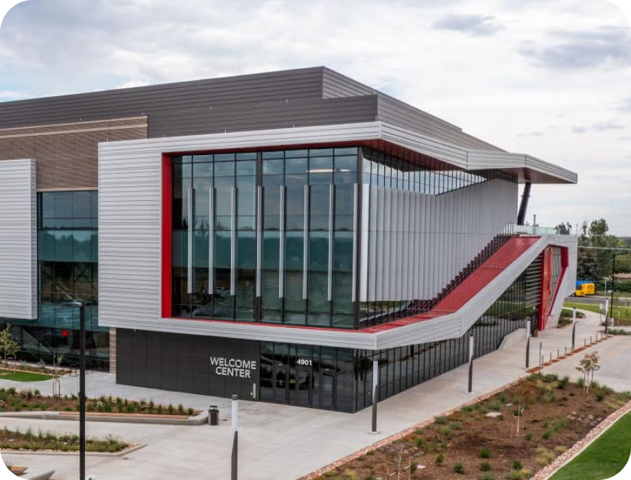 Modern building with large windows and an artistic red staircase.
