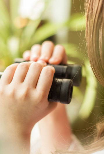 child holding binoculars
