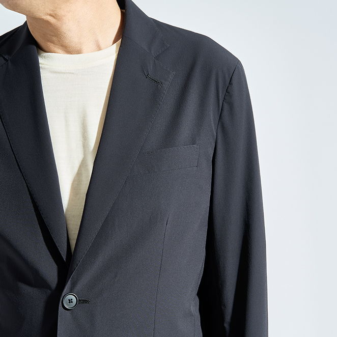 Close-up of a person wearing a black blazer over a light shirt.