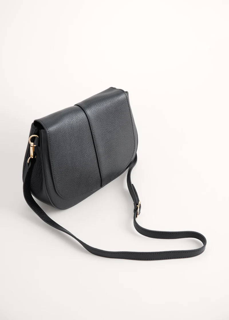 A black leather saddle handbag with a long shoulder strap