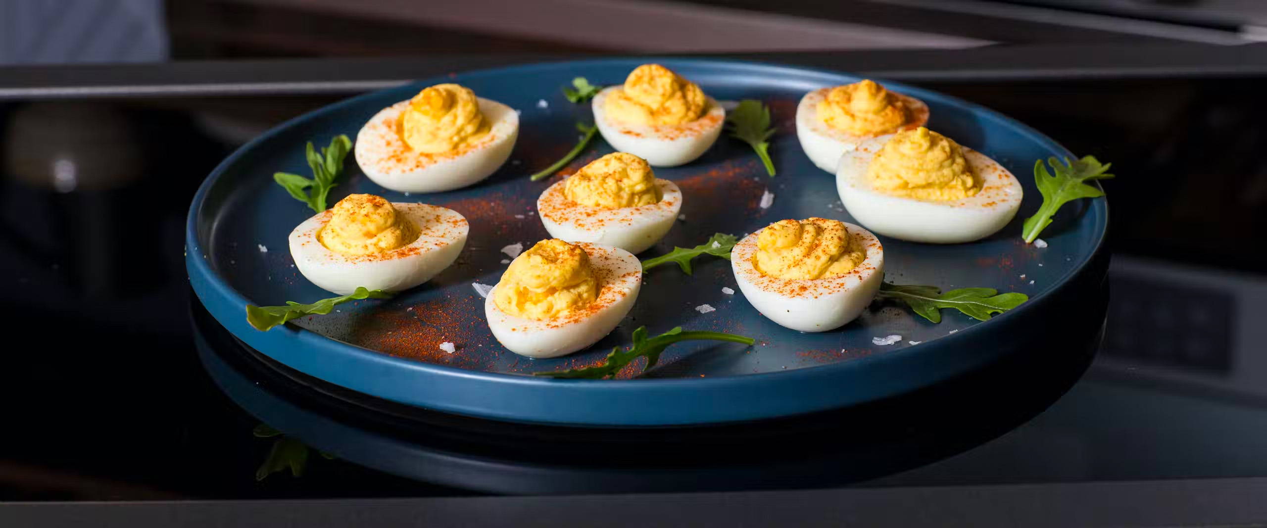 platter of classic deviled eggs with garnish.