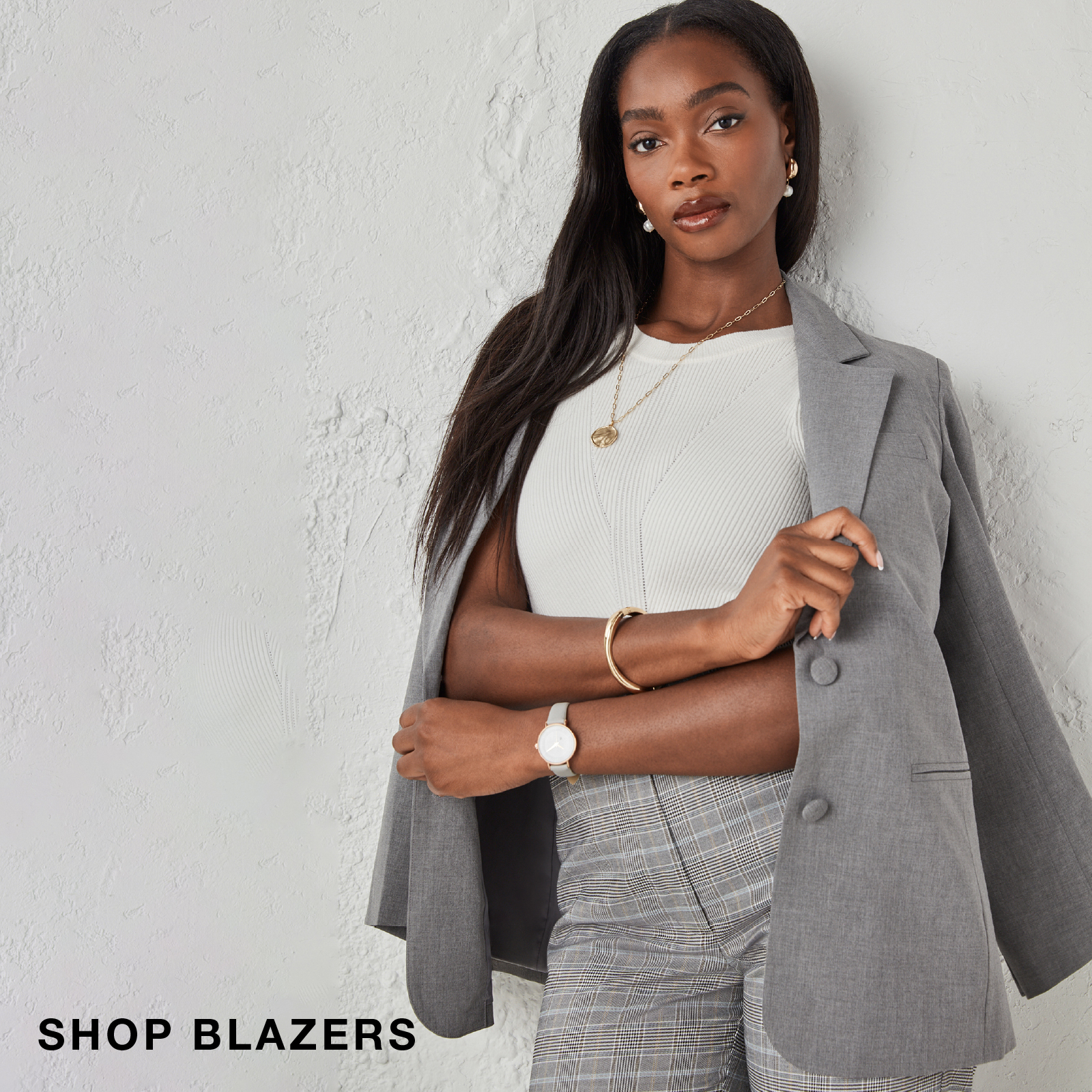 Woman wearing a gray blazer and stylish outfit, promoting blazers.