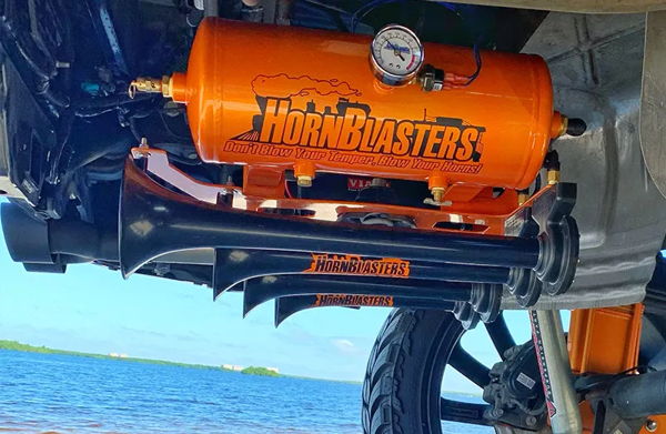 Orange HornBlasters air tank and train horns mounted under Mauricio's Silverado by the water photo 3