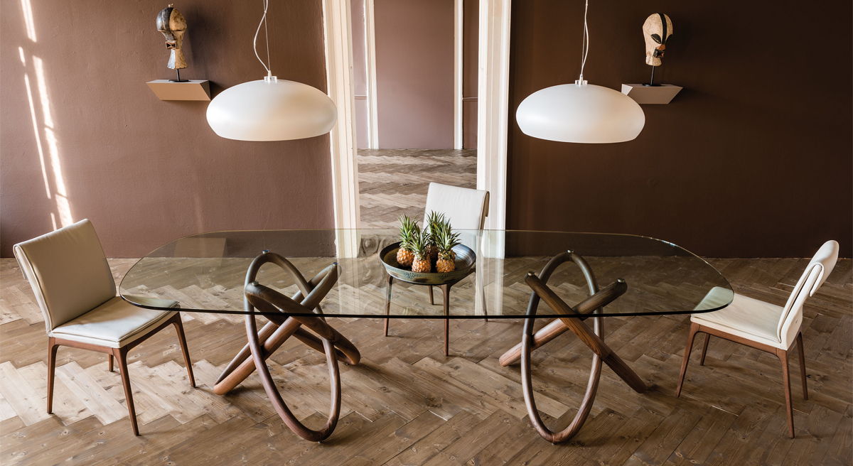 Modern Cattelan Italia dining table with four chairs and decorative items.