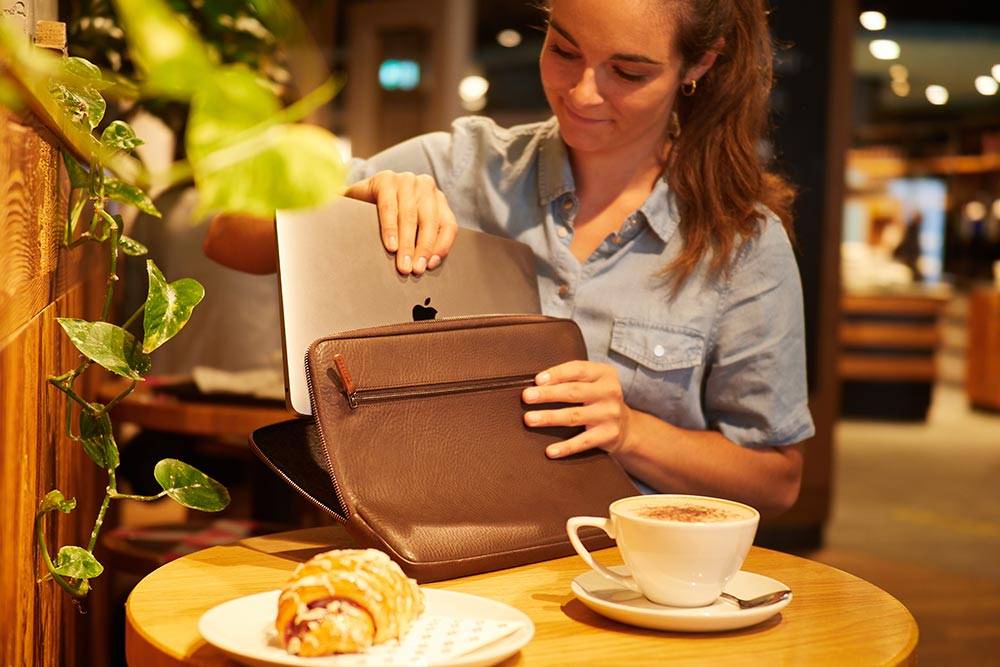 Frau steckt Laptop in Macbook Hülle von Goodwilhelm