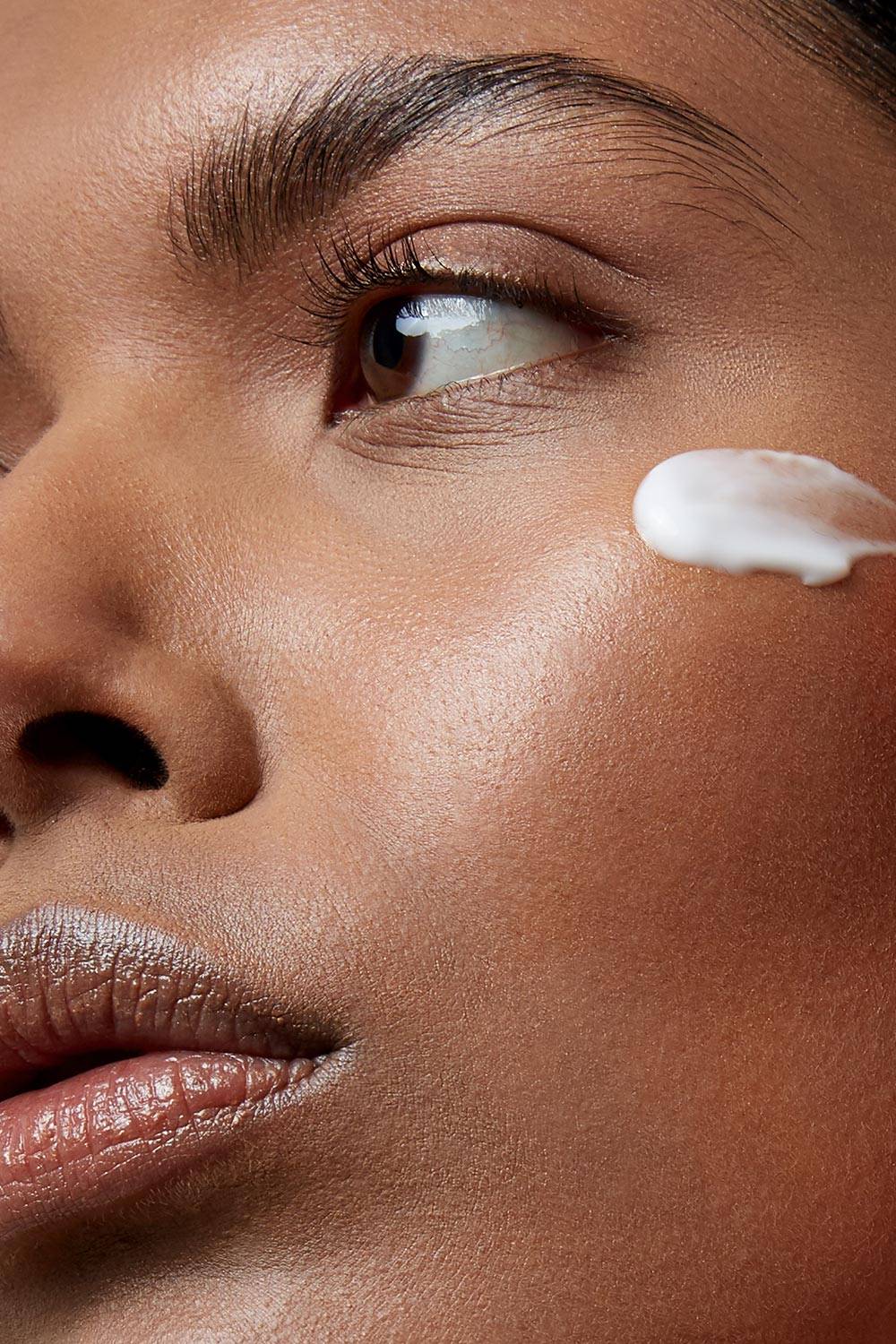 model with Super anti-aging face cream on cheek