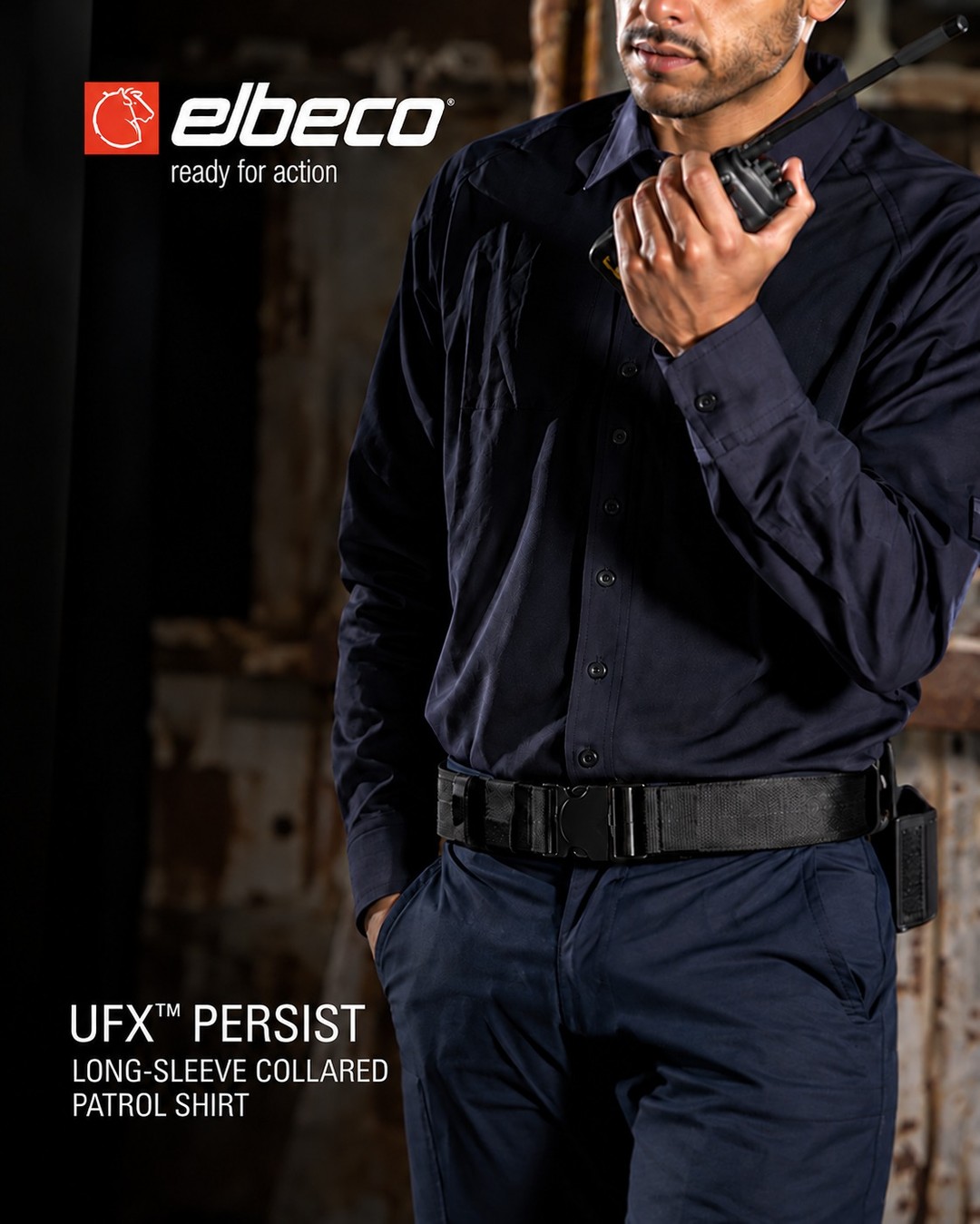 Man wearing a dark collared shirt, holding a radio device.