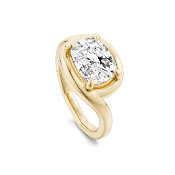 Gold ring featuring a large, cushion-cut diamond.