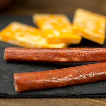 Snack sticks with cheese slices in background