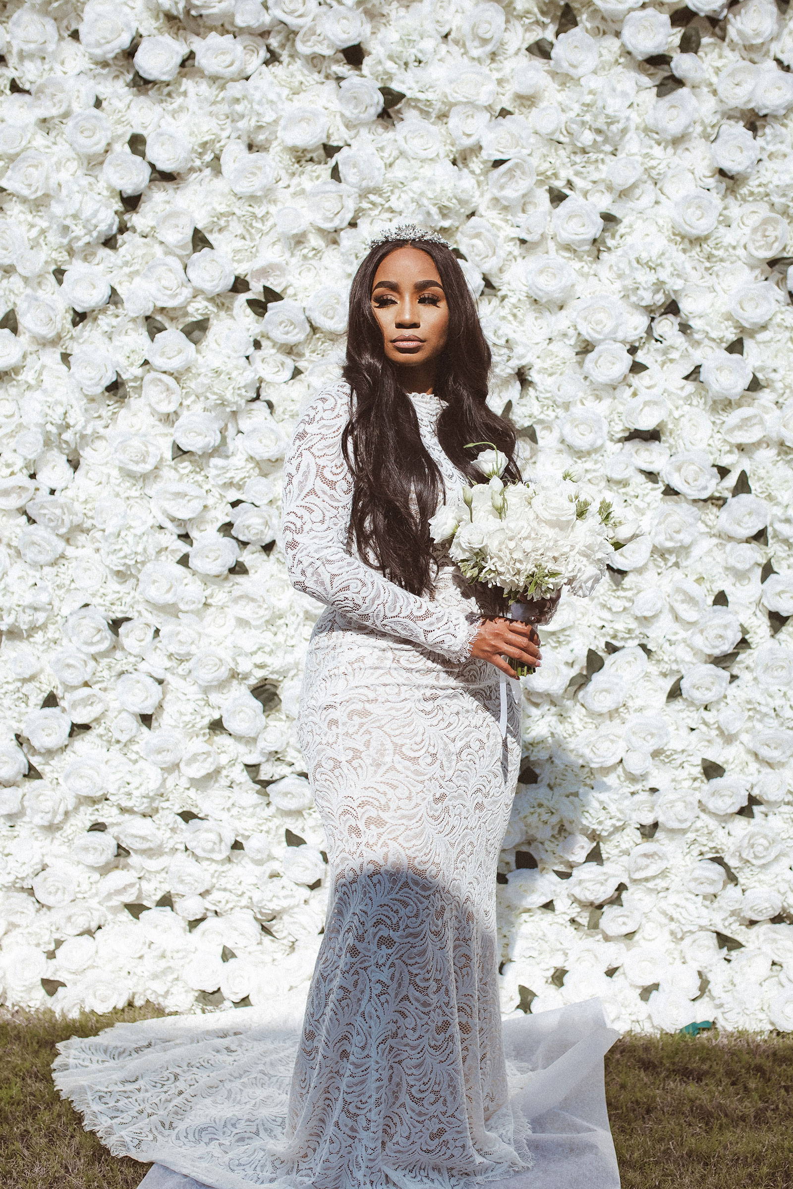 Stunning bride in the Orla wedding dress with a white flower wall