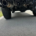 Rear undercarriage view showing train horn and exhaust on lifted RAM pickup