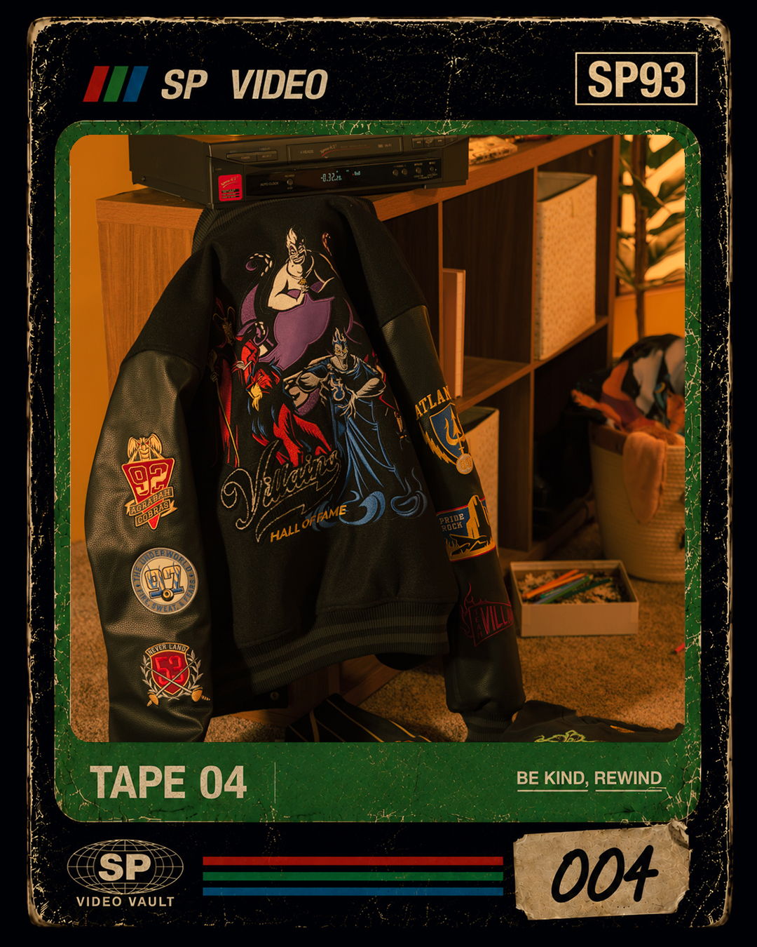A black jacket with colorful patches hanging on a shelf.