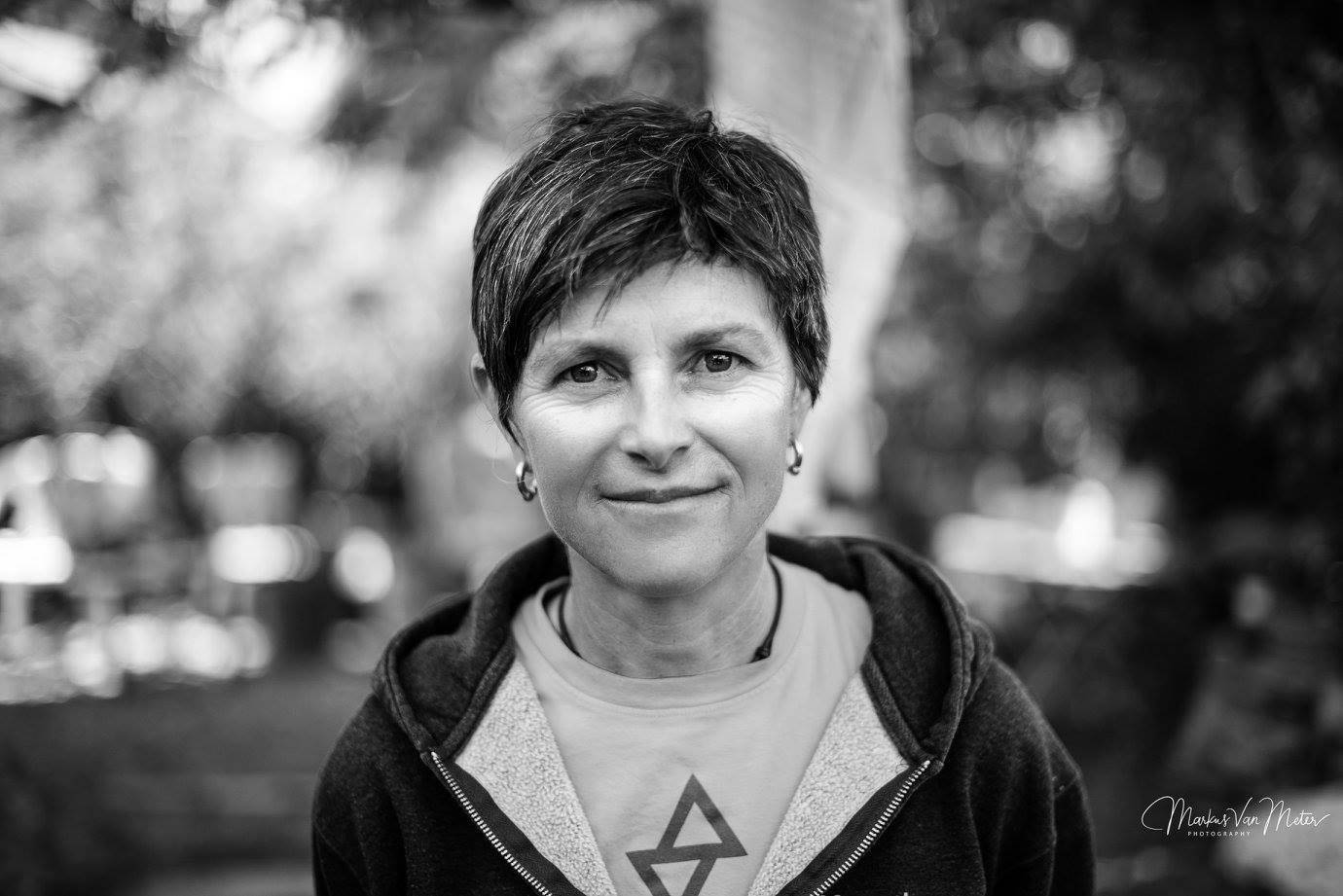 black and white photo of Angela Hawse looking at the camera, wearing a Sterling logo shirt