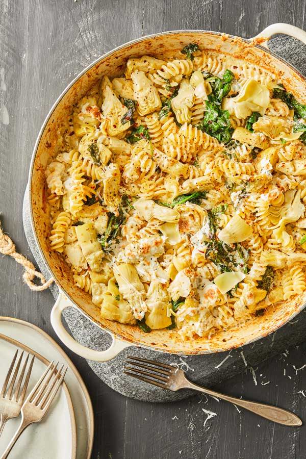 Fusilli pasta in a creamy sauce with spinach and artichokes