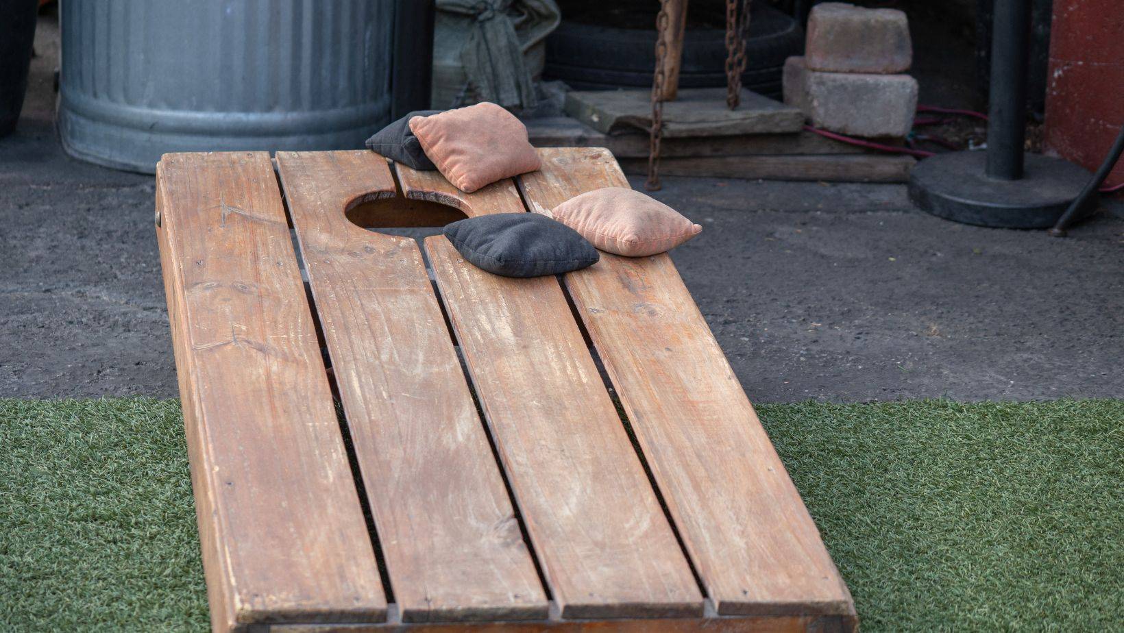 Sets of beanbags in competitive game of cornhole on a lumber platform