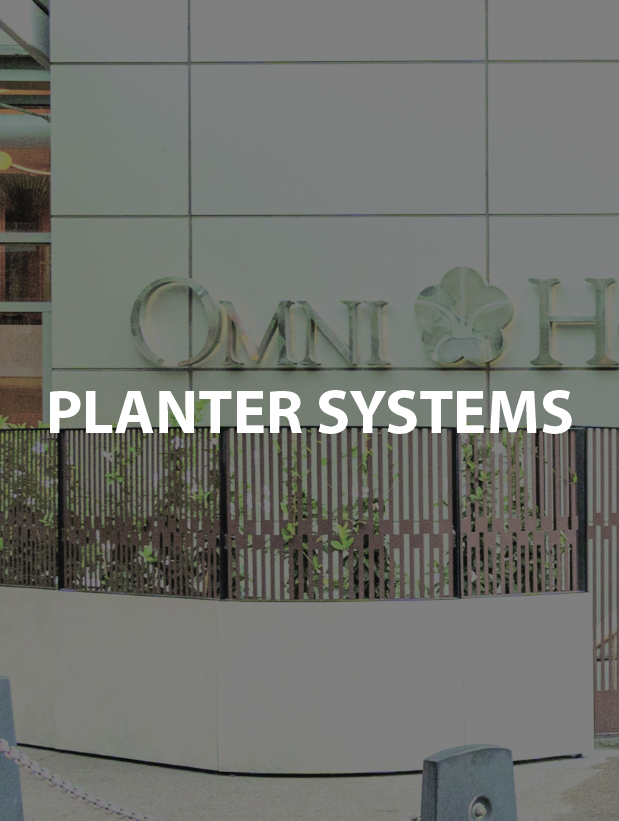 Signage for Omni Hotel with decorative plants and modern architecture.