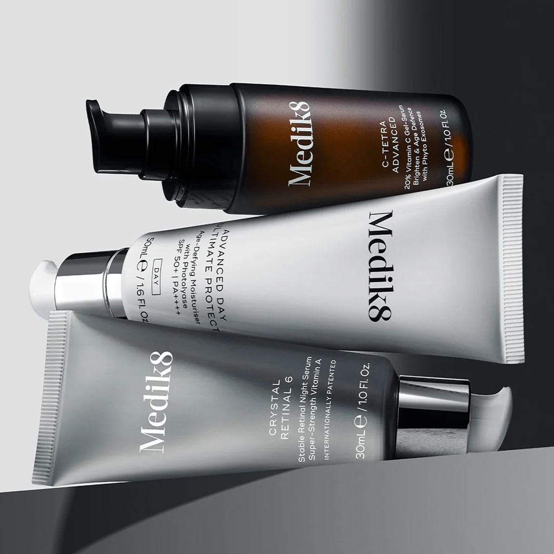 Three skincare products stacked against a gradient background.