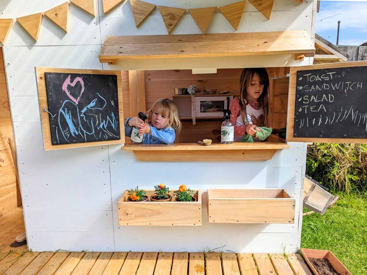 A sustainable wooden cubby house getting a spring clean