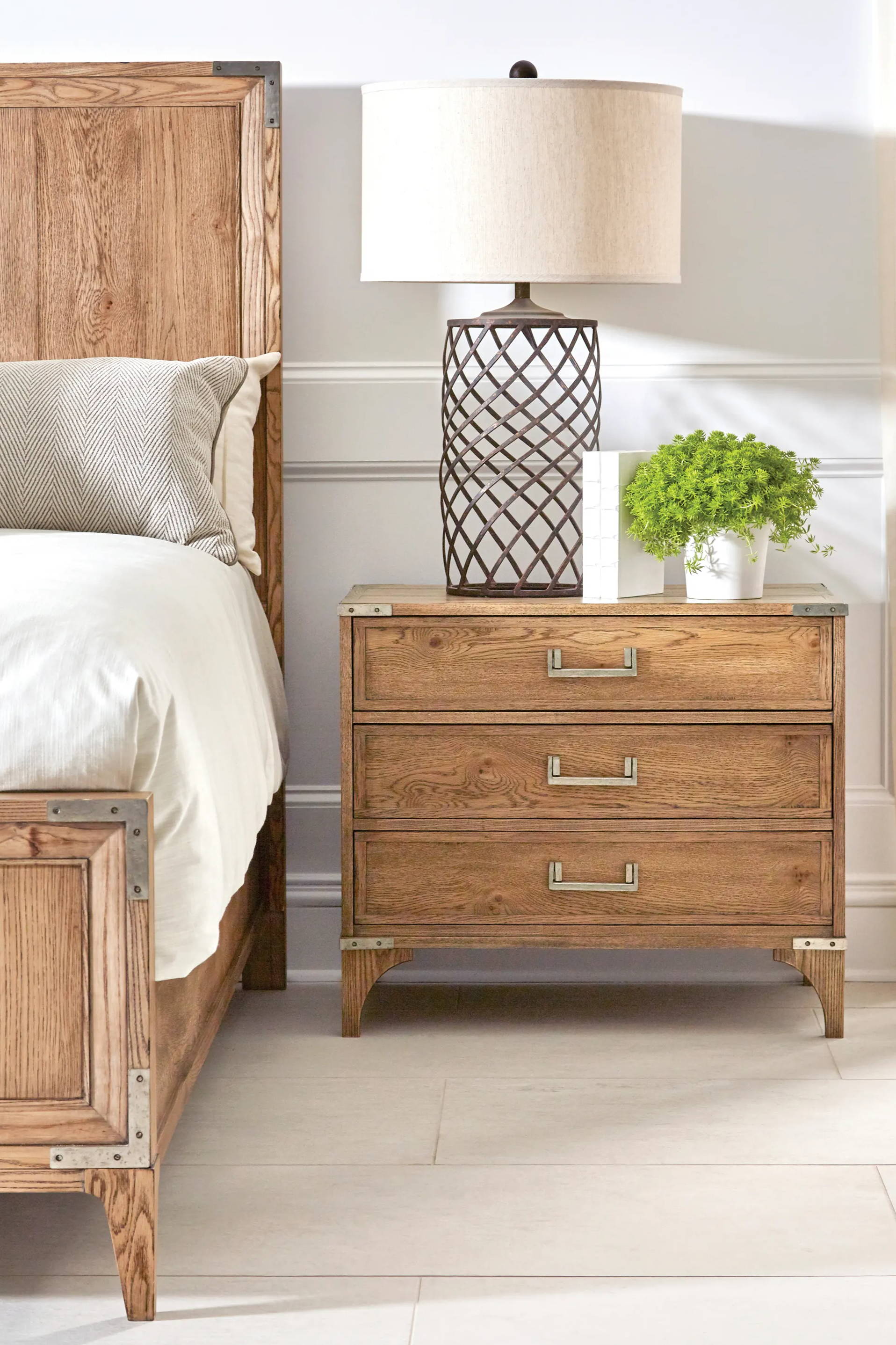 wood nightstand with lamp next to wood bed