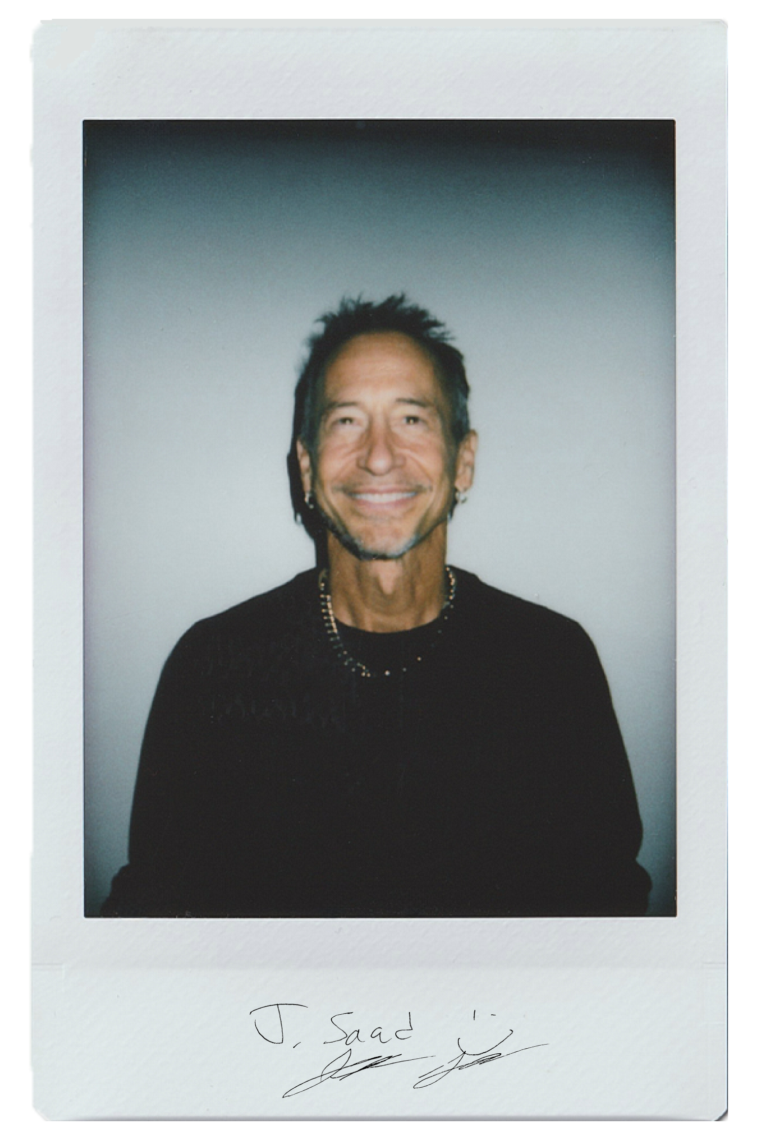 Smiling man in a black shirt, with a polaroid frame and signature below.