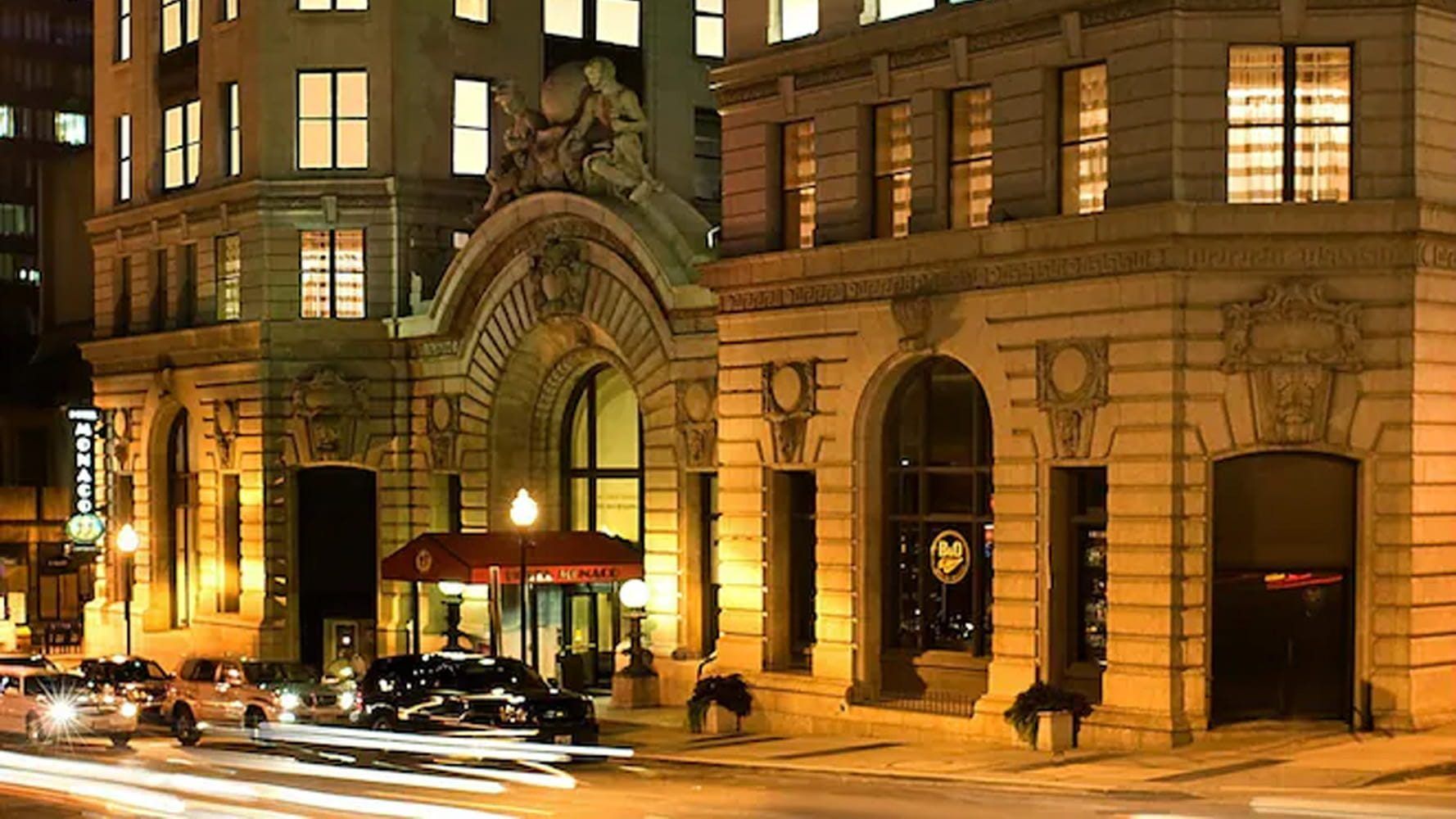 Exterior of Kimpton Hotel Monaco Baltimore at night, the historic 1906 B&O Railroad building on North Charles Street near Power Plant Live!