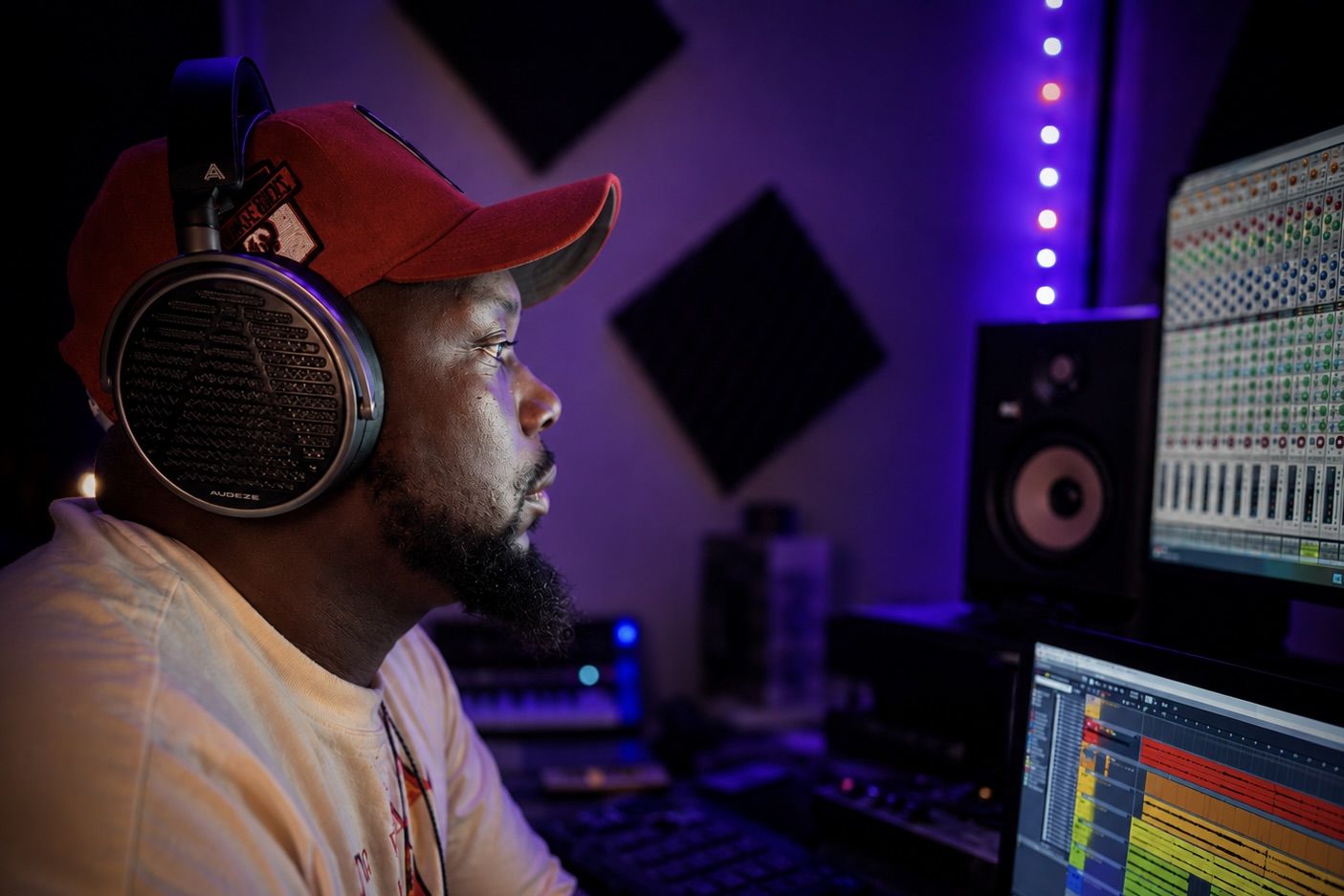 Brian Watson wearing Audeze MM-100 headphones working at a music production studio.