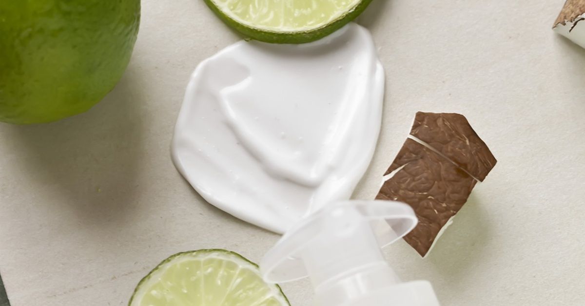 White cream, lime slices, and a tea bag on a light surface.