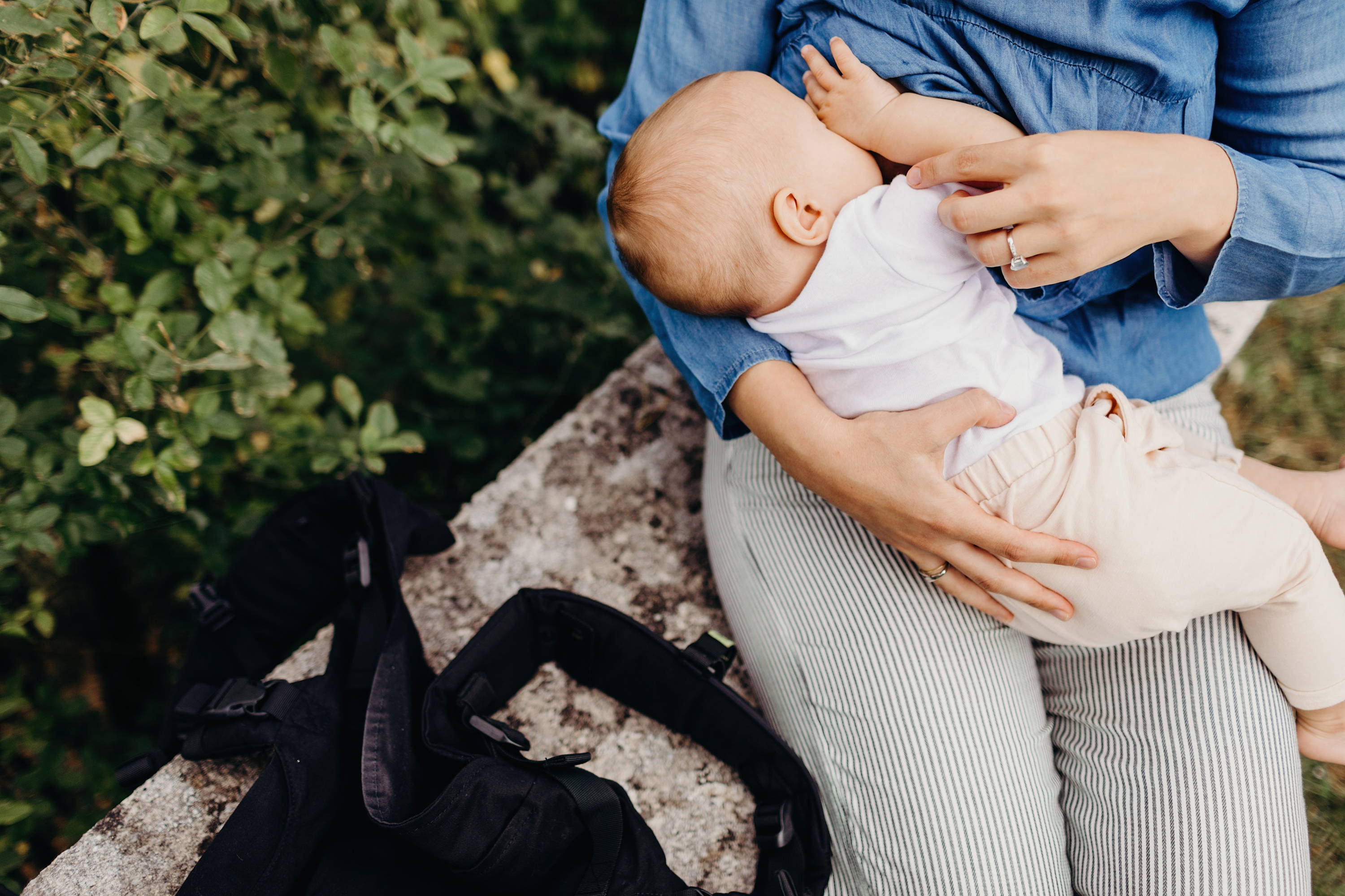 Sleepy baby breastfeeding with mom wearing a denim shirt