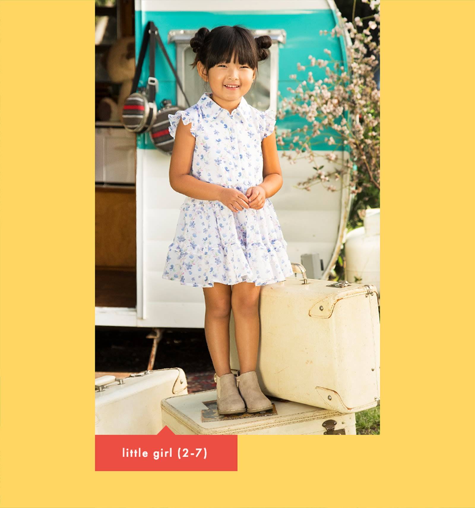 an image of a little girl wearing asundress smiling while outside