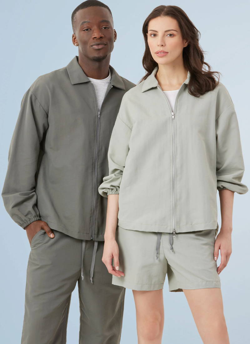 Two models wearing matching light gray outfits.
