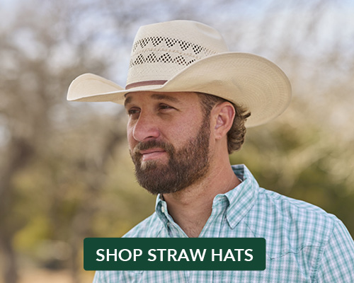 A man wearing a cowboy hat and checkered shirt outdoors.