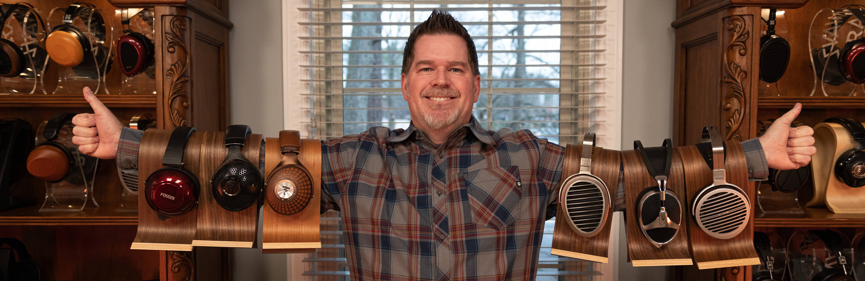 Drew Baird with 6 headphones on his arms Fostex TH900mk2, Focal Utopia 2022, Focal Stellia, HiFiMan He1000v2, Meze Elite, HiFiMan Susvara