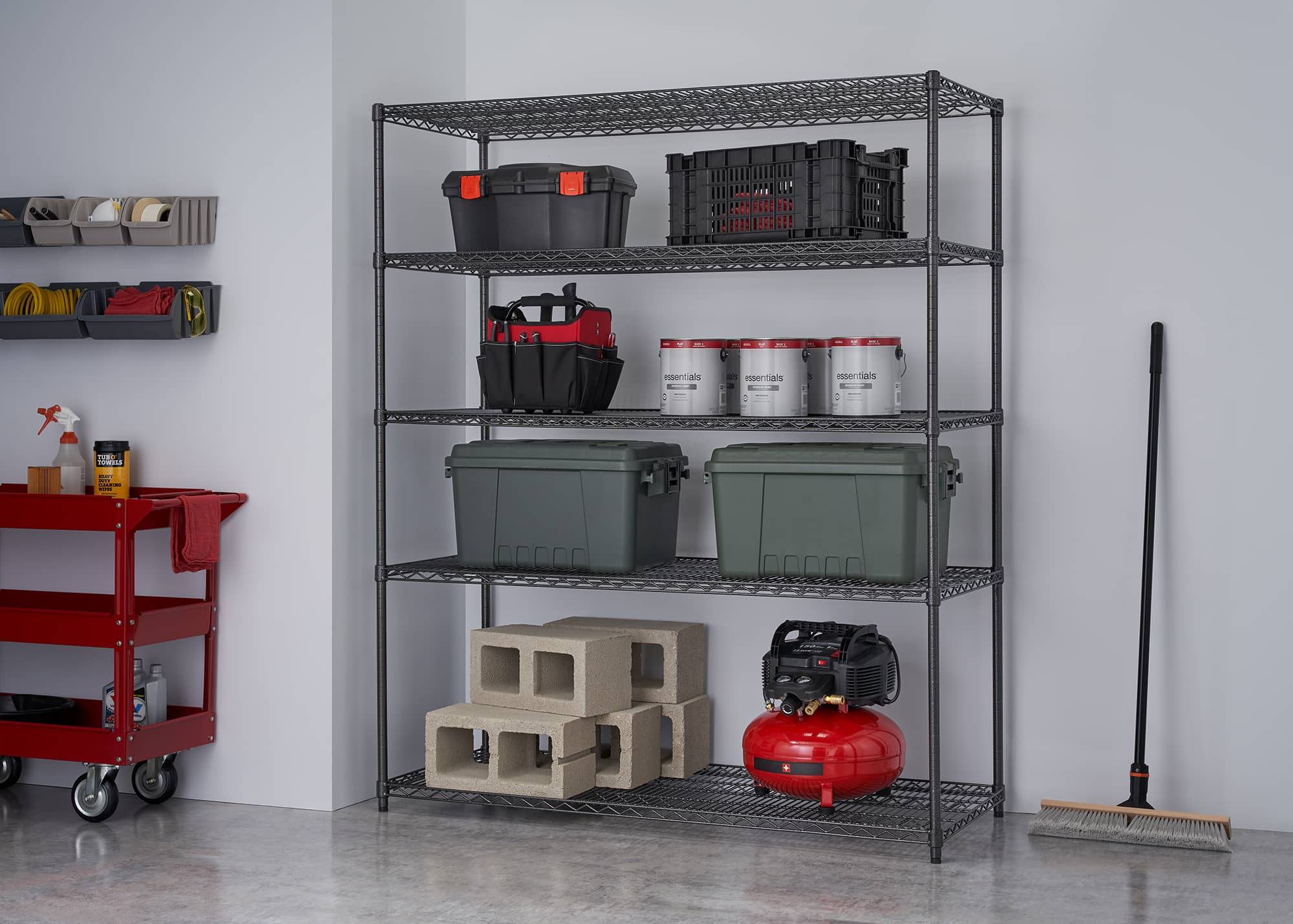wide black wire shelving rack filled with home construction materials and tool boxes