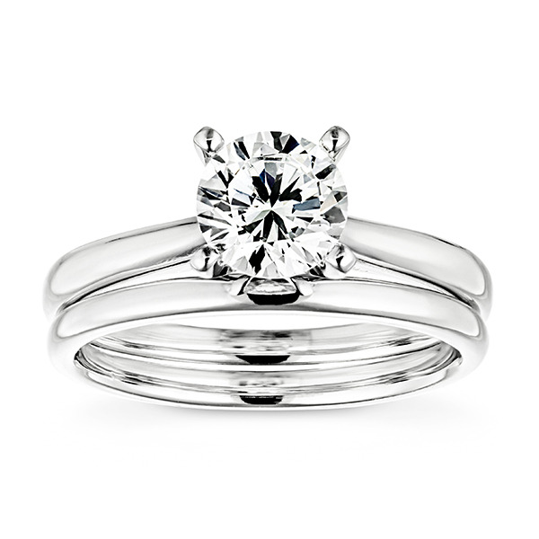 A simple and minimalistic white gold wedding ring set featuring a solitaire and matching solid band