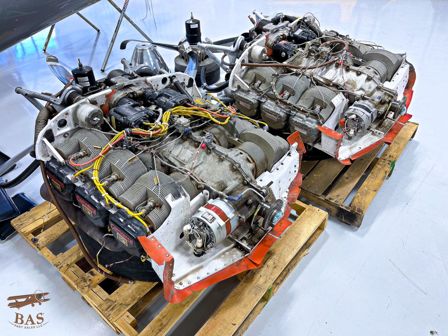 Two aircraft engines on wooden pallets with visible wiring and components.