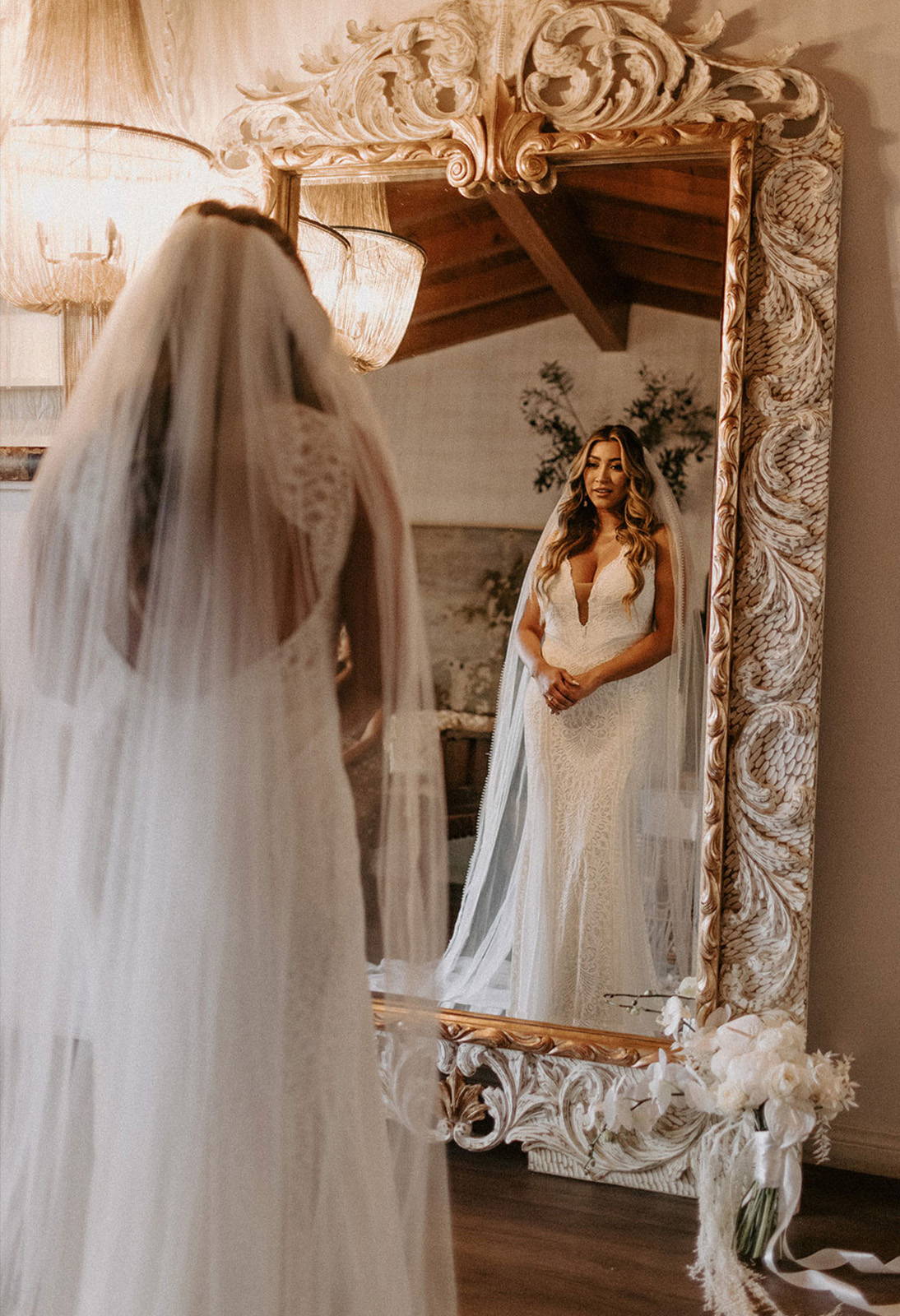 Bride looking in mirror at Chelo Gown and Veil