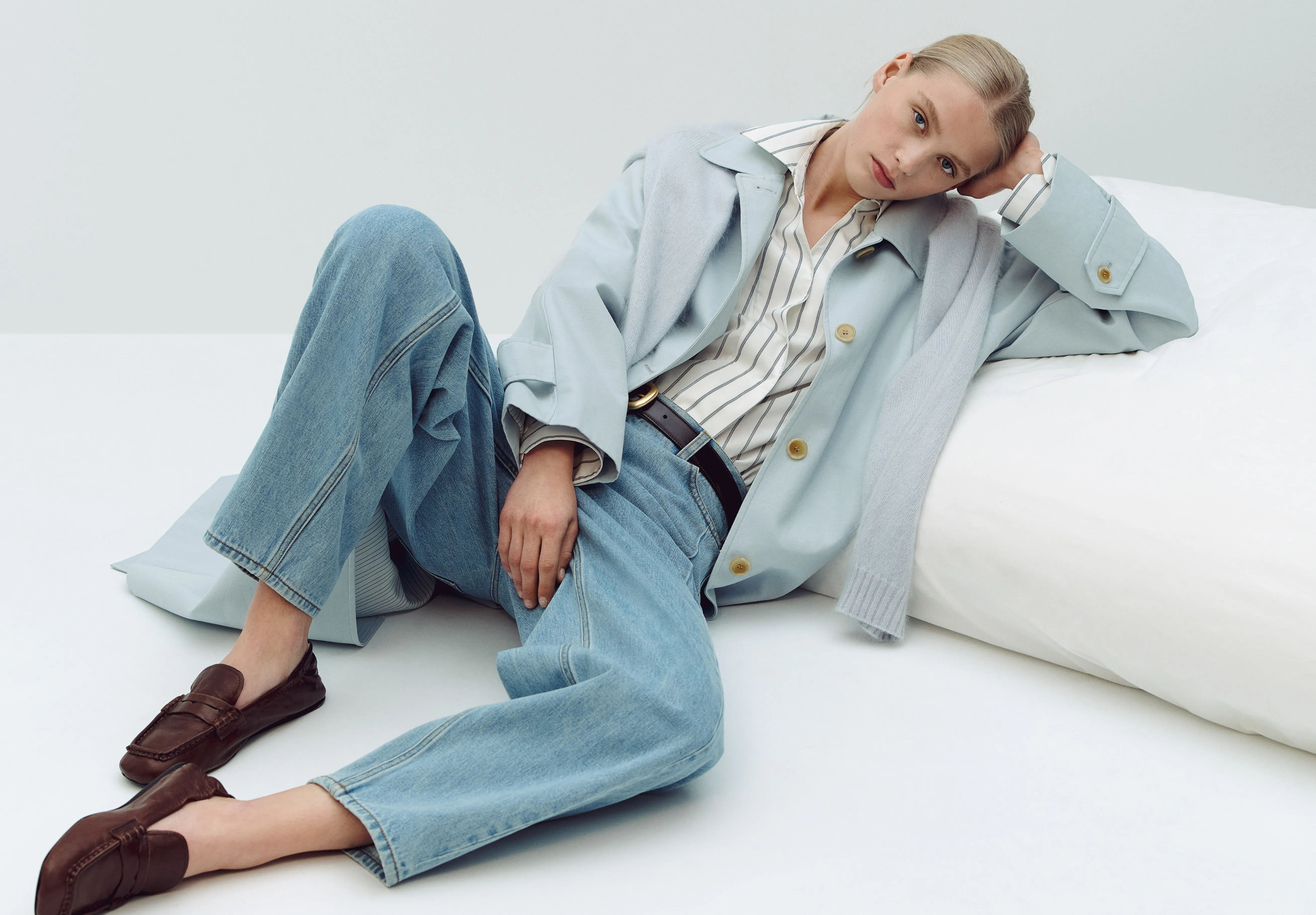 Person in casual outfit lounging on a white couch.