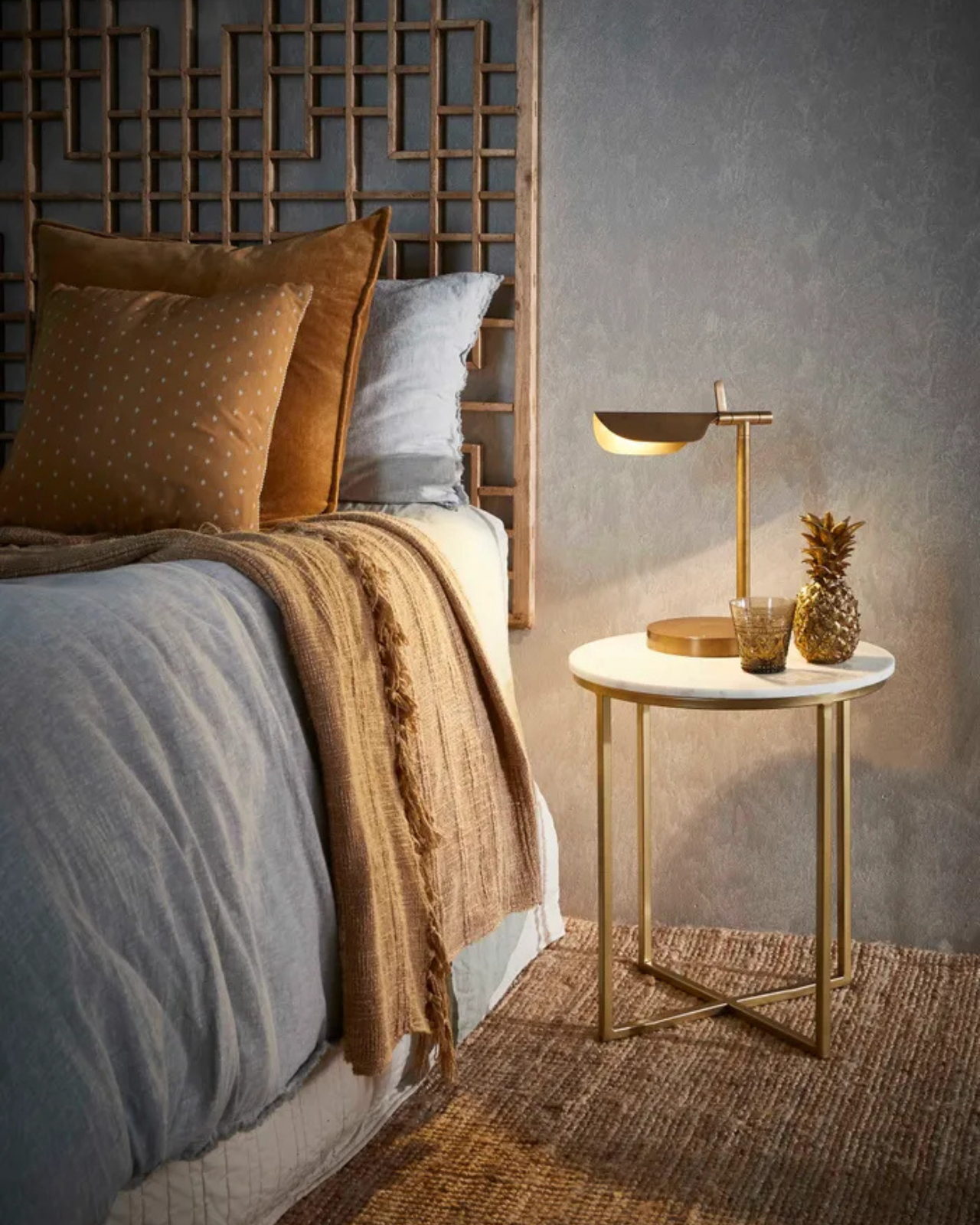 Brass Lamp on a Side Table in a warmly toned bedroom