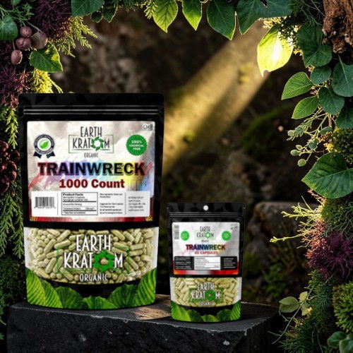 Two packages of Trainwreck kratom surrounded by lush greenery.