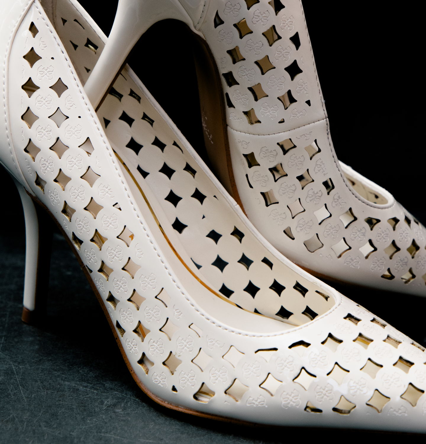 GUESS white high-heeled shoes with cut-out designs and a sleek silhouette.