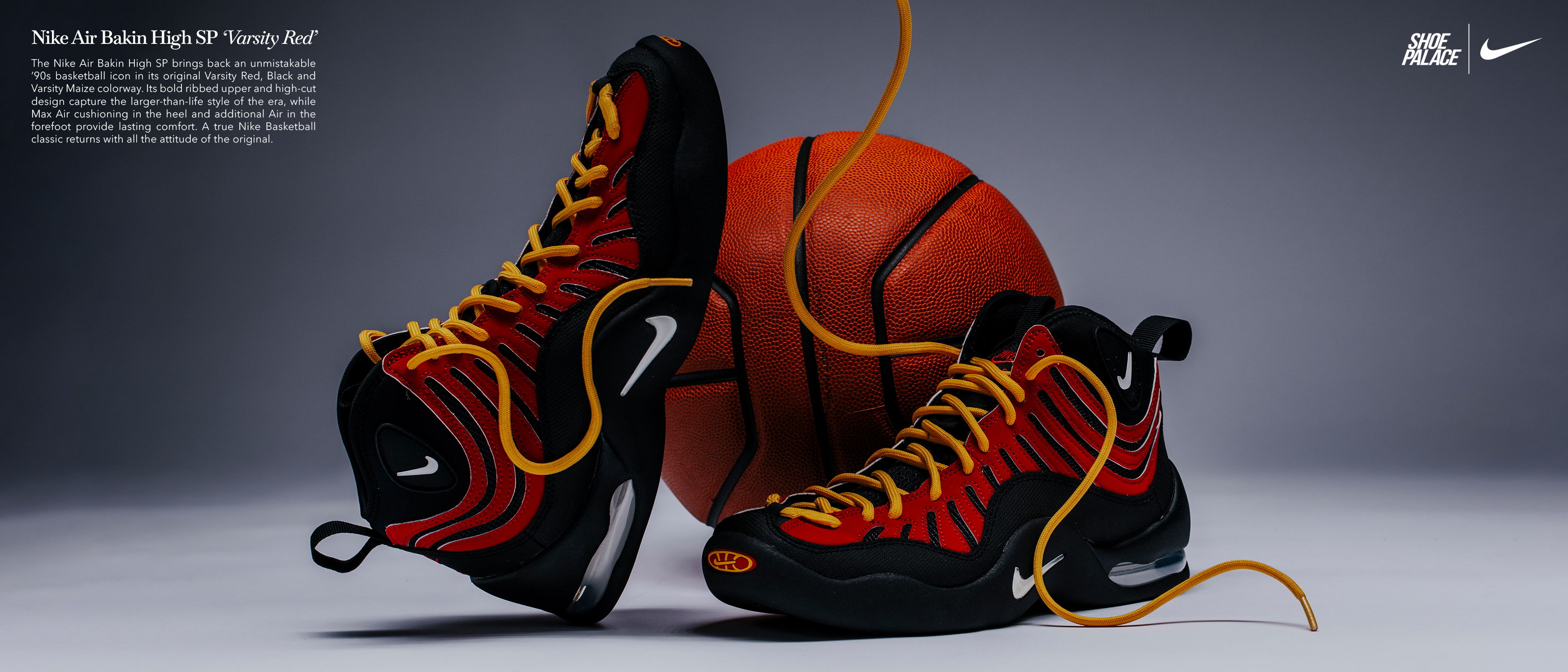 Basketball shoes next to a basketball on a gray background.