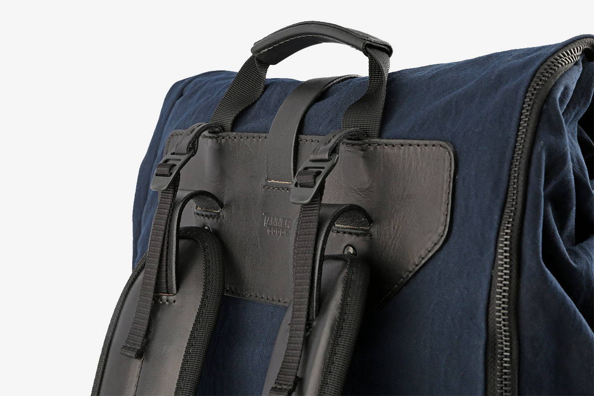 A navy blue backpack with adjustable strapping at the top of the shoulder pads.