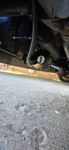 Close-up of black horn solenoid with braided air line and blue wiring mounted under vehicle