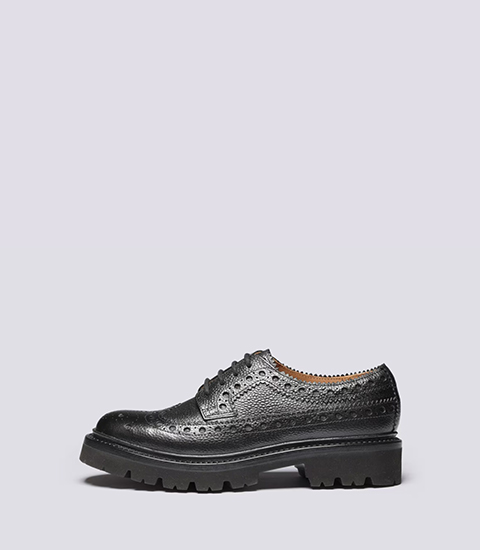 Women's Black brogue shoe with a chunky sole on a light background.