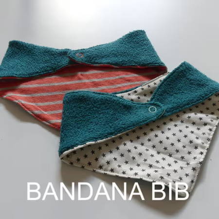 Two reversible bibs, triangular shaped, with a snap button