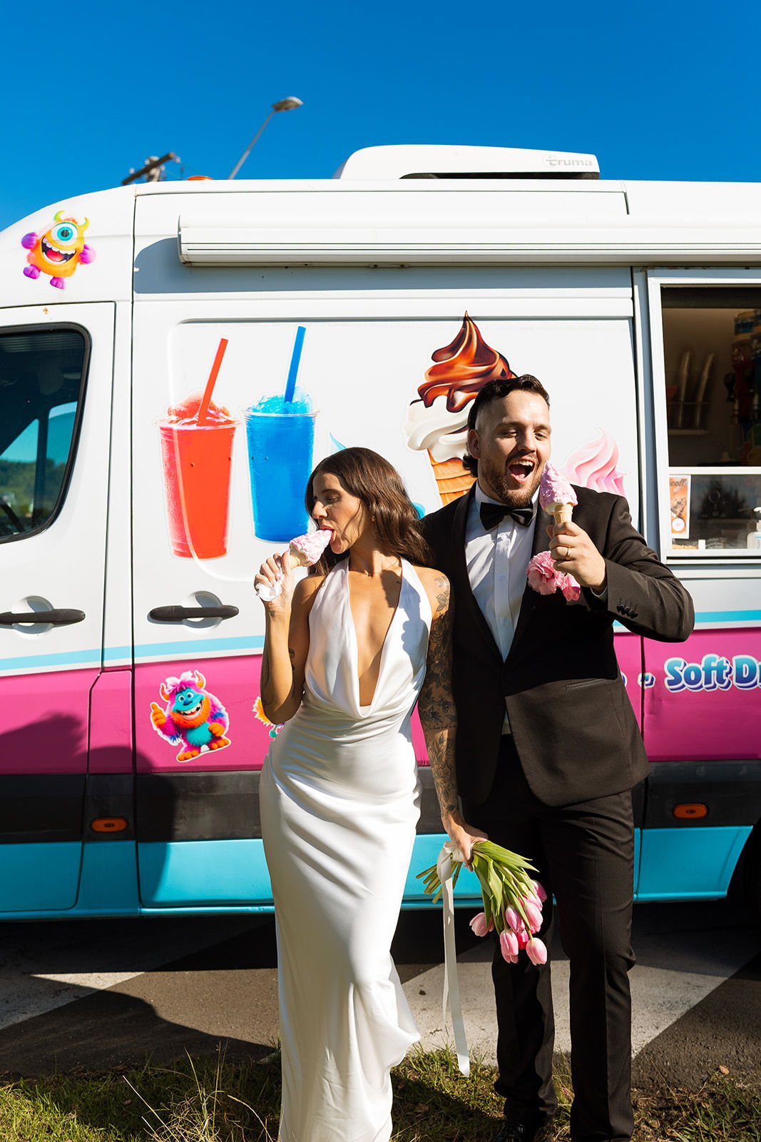 Couple celebrating with ice cream truck, holding tulips and enjoying treats.